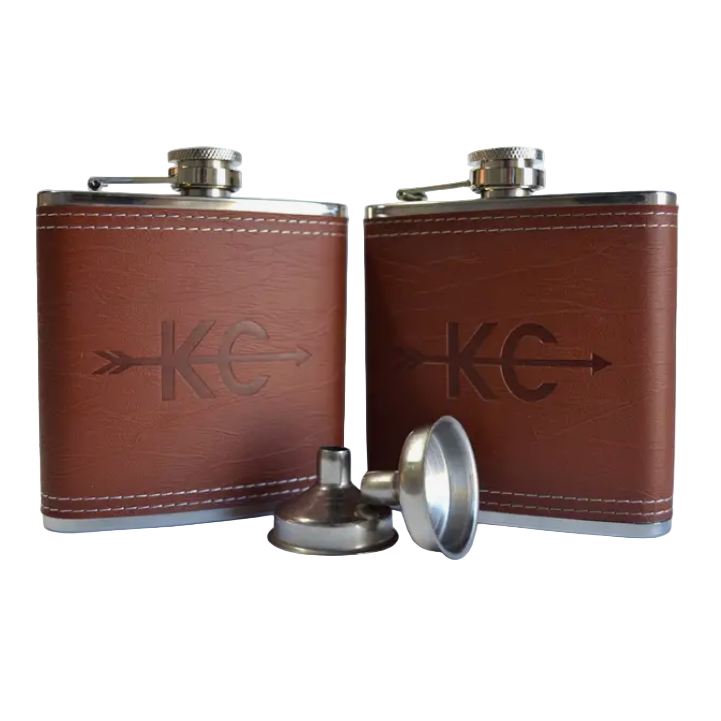Two brown vegan leather flasks with metal caps and a funnel on a white background