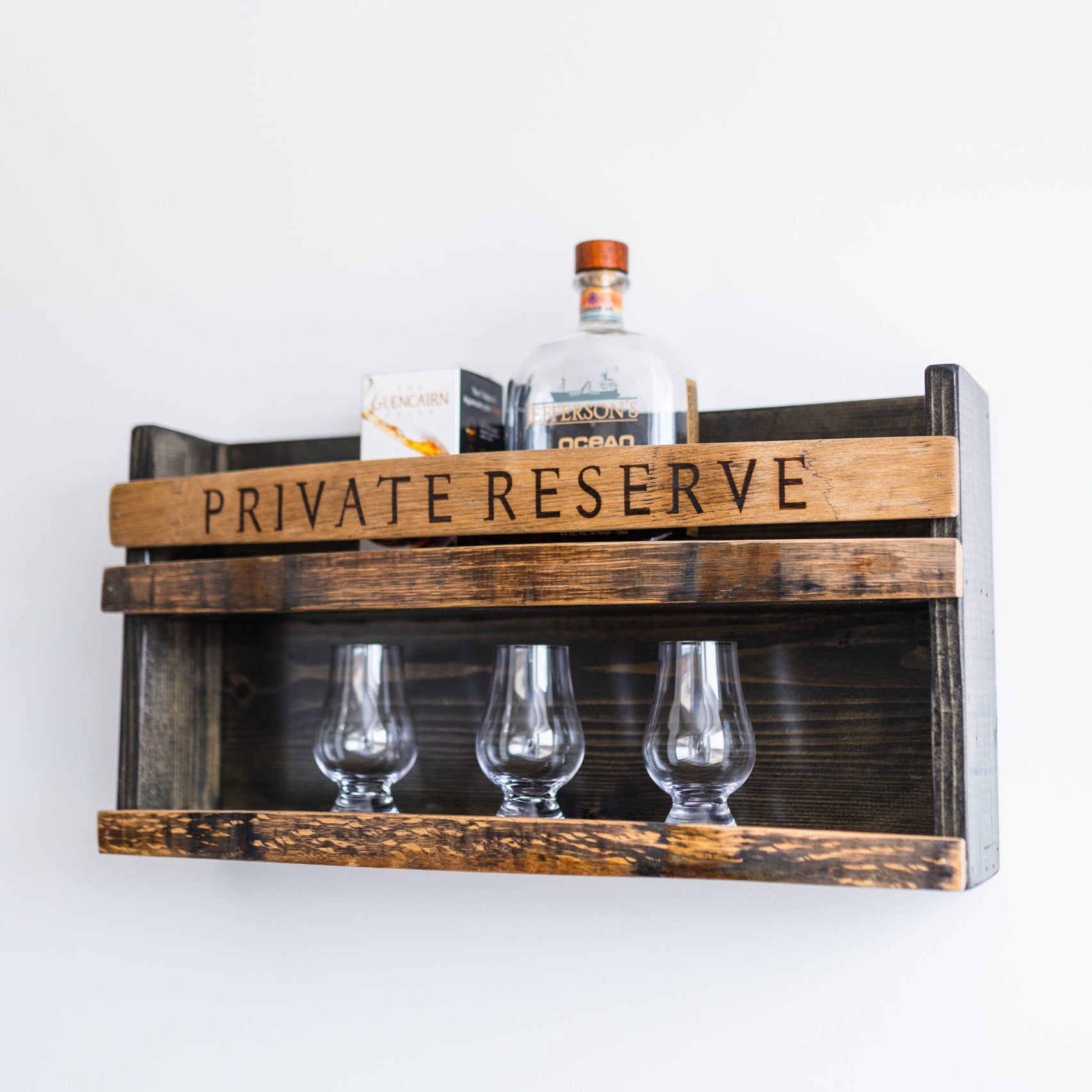 Wooden shelf with 'PRIVATE RESERVE' inscribed on the wood, holding glasses and liquor, on a white background