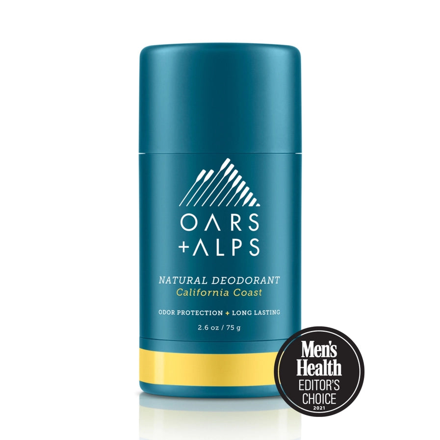 A stick deodorant with blue packaging labeled 'OARS + ALPS NATURAL DEODORANT california coast'. There is a Men's Health Editors Choice badge displayed in front of the product.