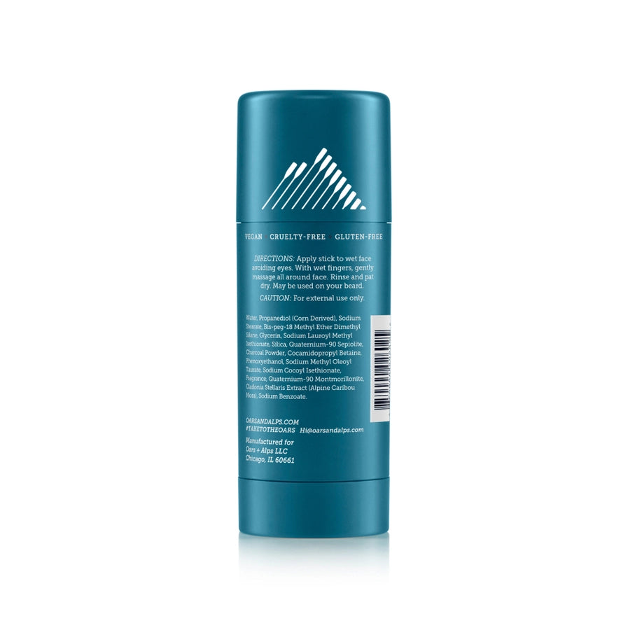 The back of a blue container of Oars + Alps Exfoliating Charcoal Solid Face Wash with the ingredients and details about it in white text.