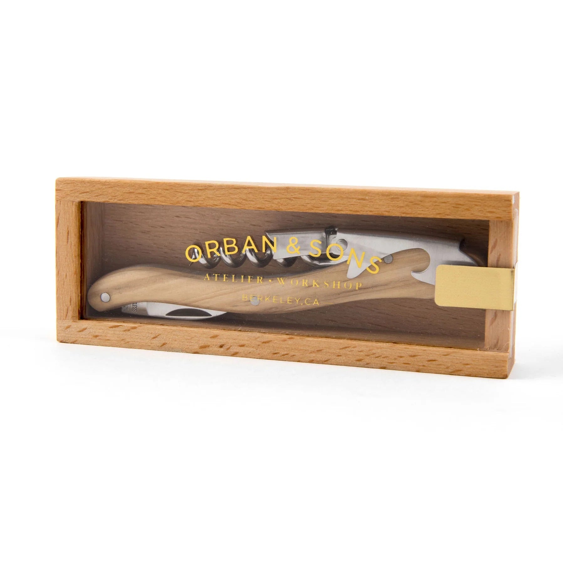 A useful multi-tool for wine purposes with a foil cutter, bottle opener, and corkscrew inside of a wooden box with a clear top and 'Orban & Sons' written on top.