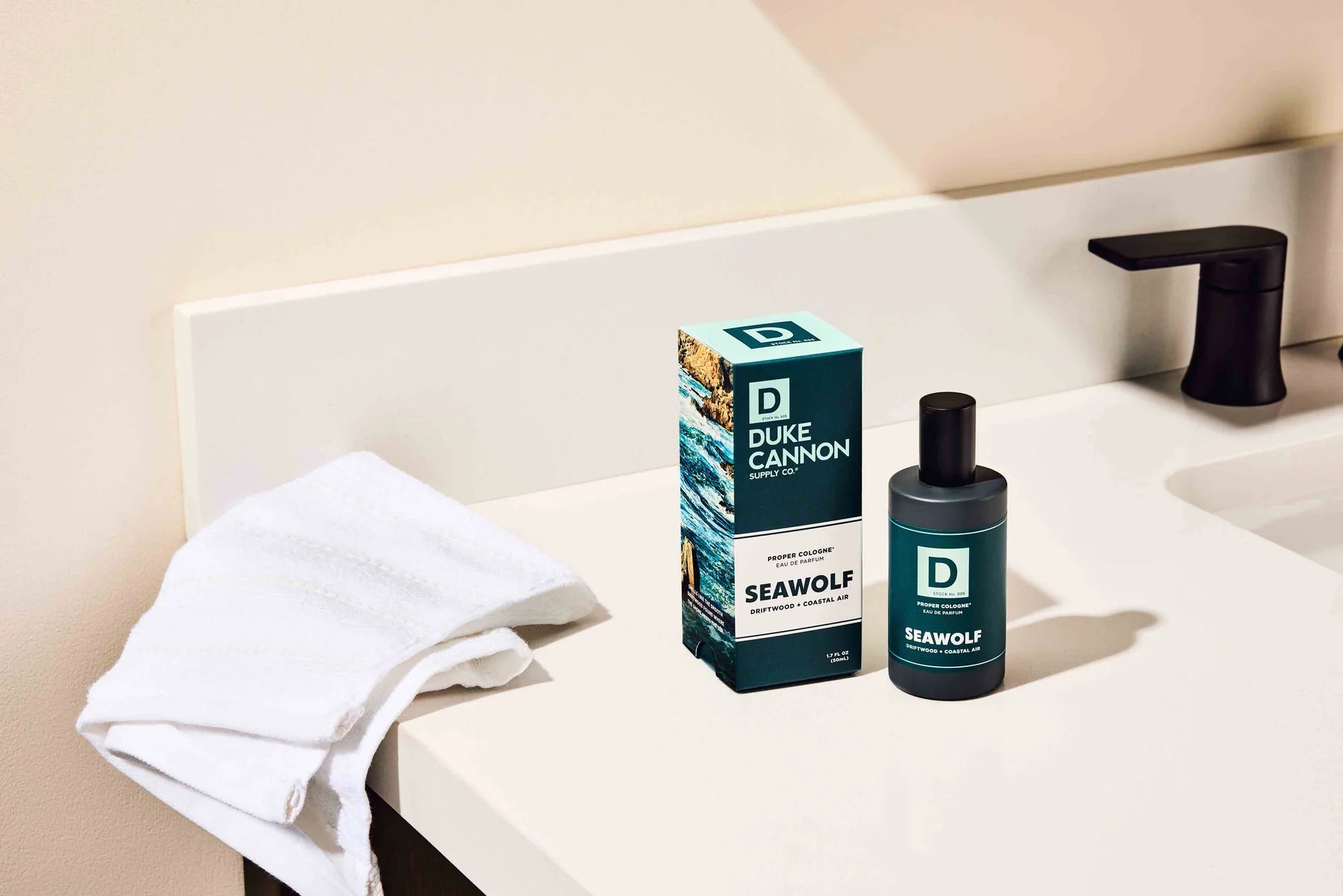 Duke Cannon Seawolf product on a bathroom counter with a towel and soap dispenser.