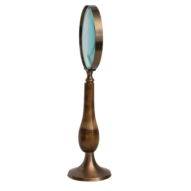 Vintage-style magnifying glass that acts as its own stand on a white background