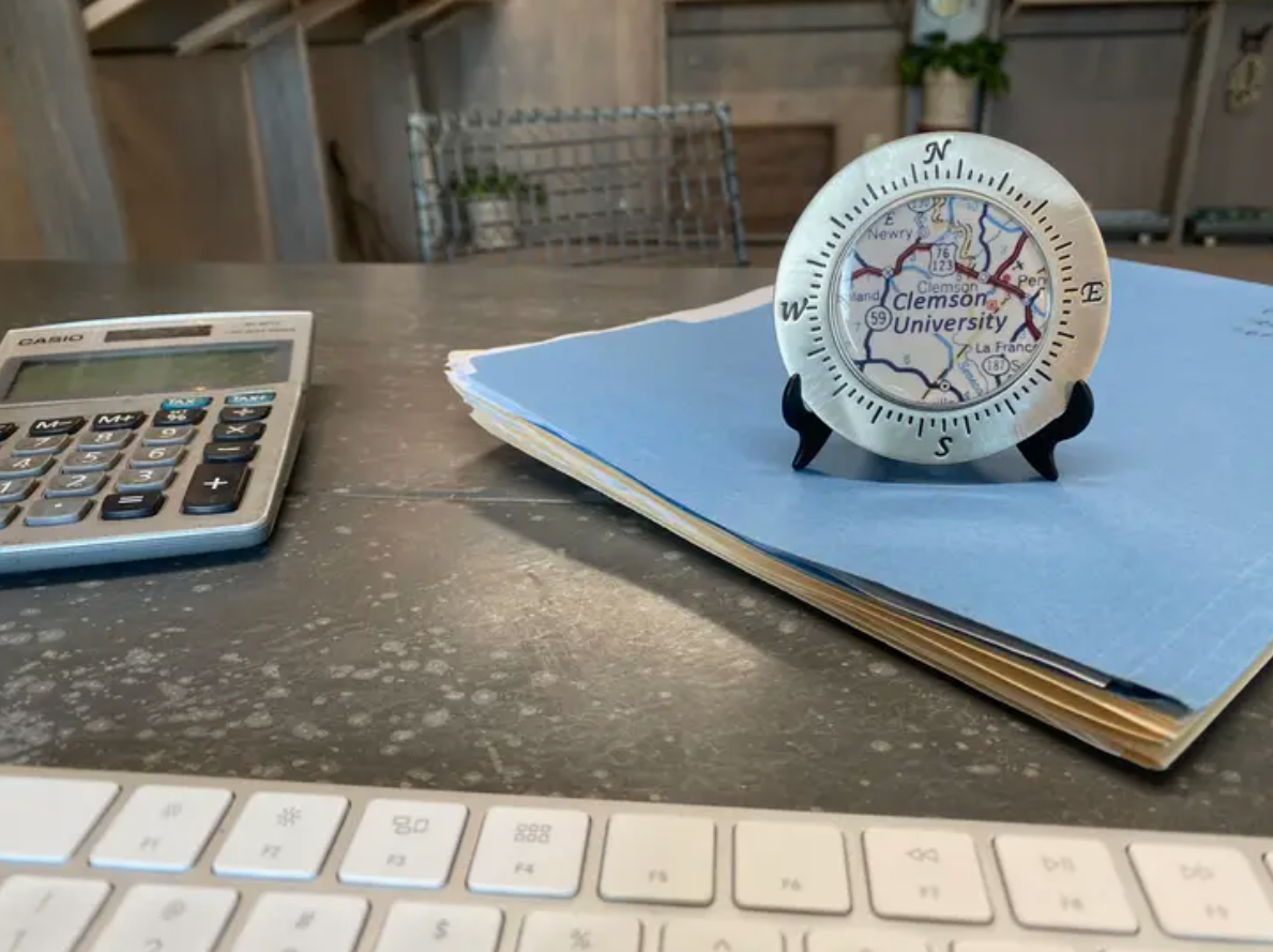 A paperweight in a display on a stack of folders on a desk.