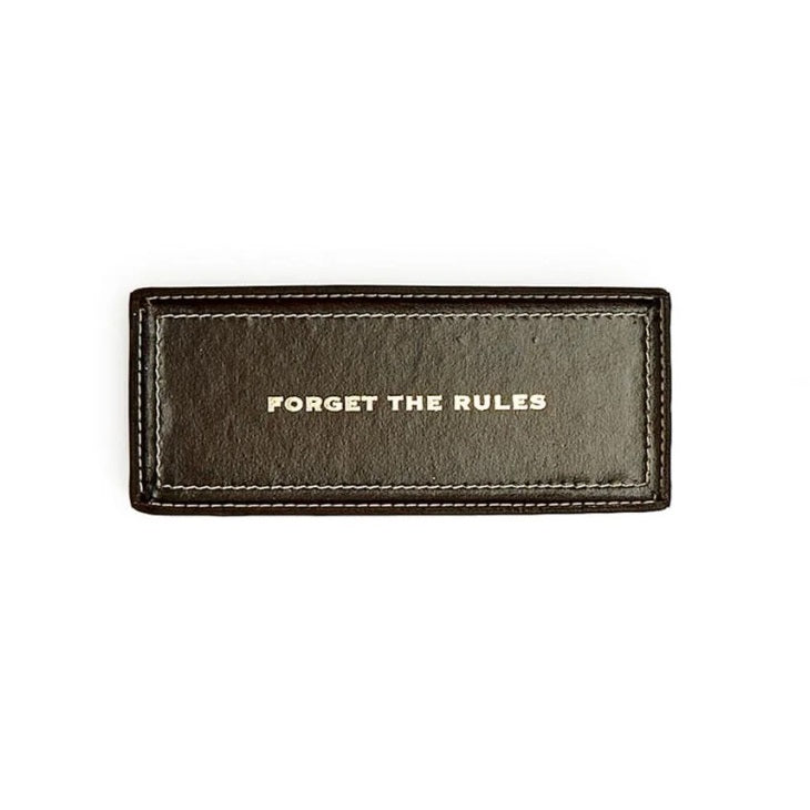 Brown leather tray with 'Forget the Rules' text on a white background