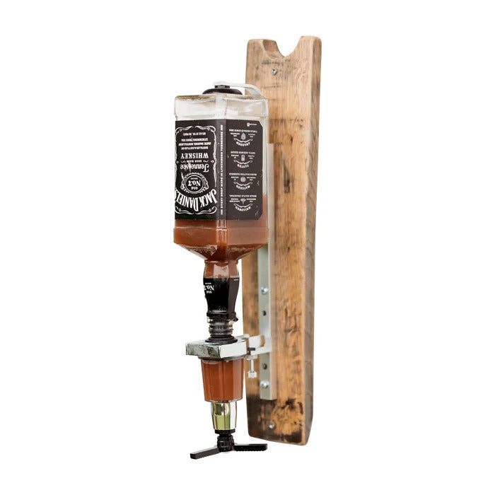A whiskey wall dispenser mounted on a wall, made from a bourbon stave with a rustic finish, featuring one spout and a bottle of whiskey.