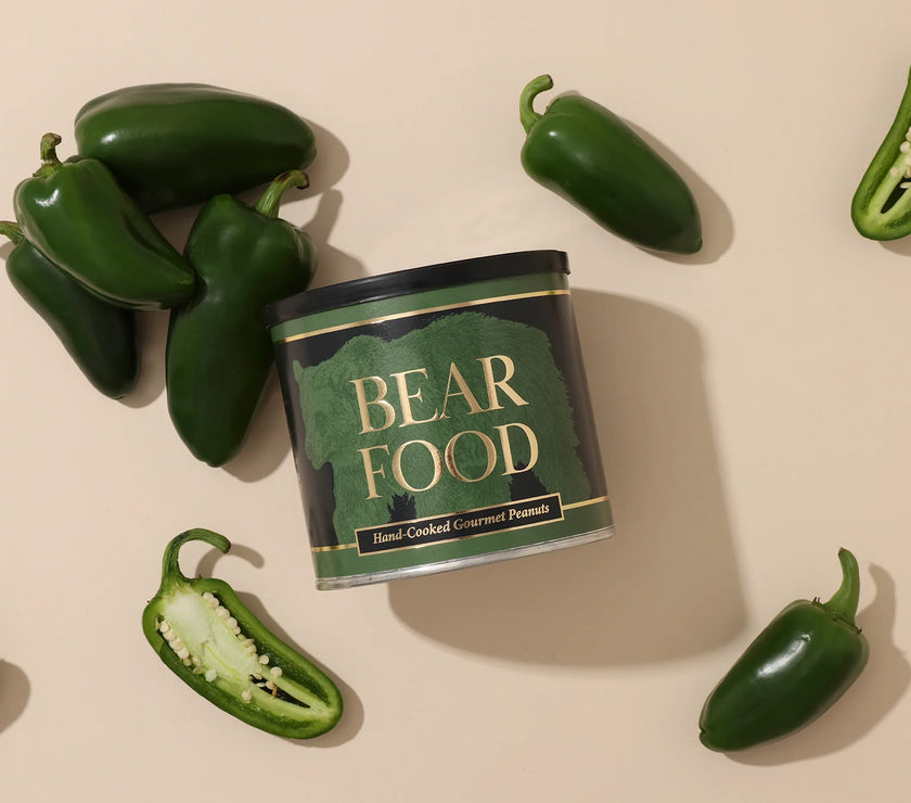 Can of 'Bear Food' surrounded by jalapeño peppers on a beige background