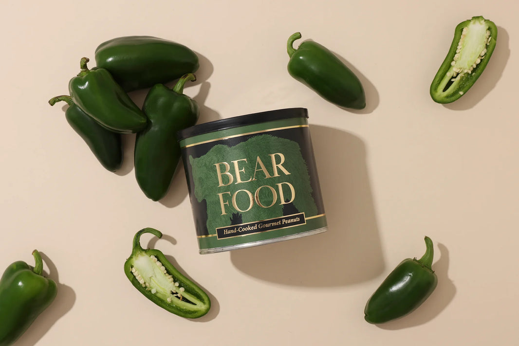 Can of 'Bear Food' surrounded by jalapeño peppers on a beige background