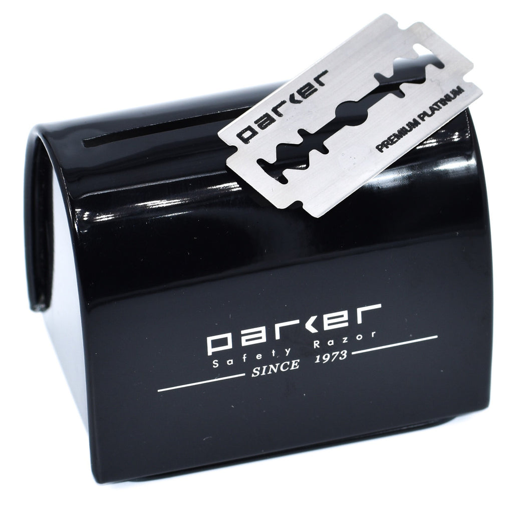 A black metal Parker blade disposal bank with a safety razor blade placed on top of it.