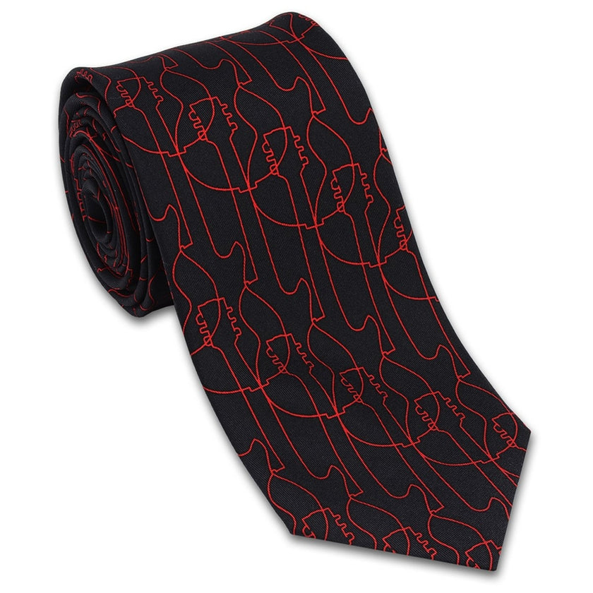 A silk necktie with a pattern of red guitars on a black background, rolled up presumably for packaging.