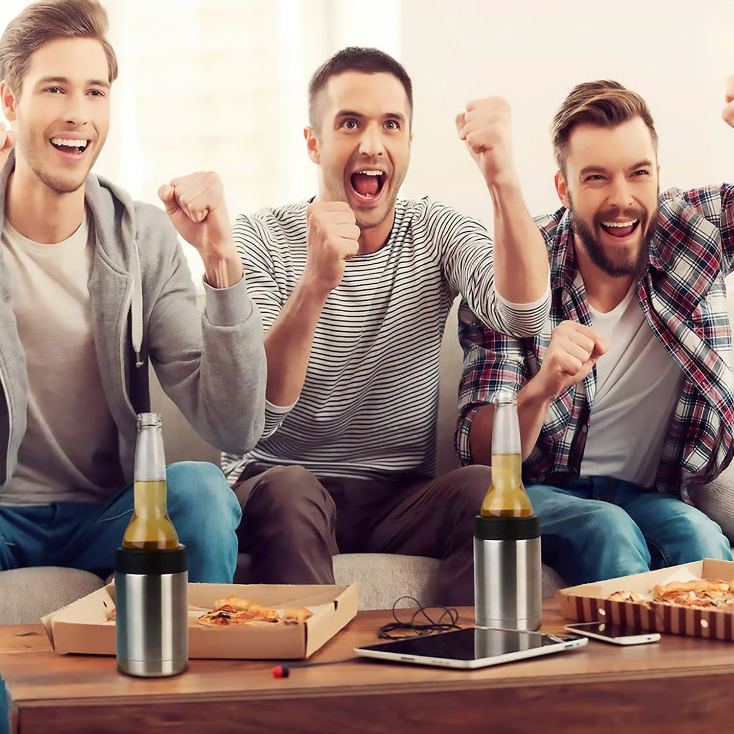 Three men celebrating with raised fists at a sports event, surrounded by snacks and bottles in stainless steel bottle holders.