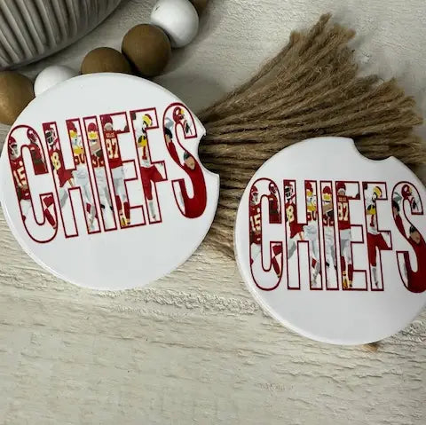 Two round white coasters with the word "CHIEFS" in large red letters filled with Kansas City Chiefs football player cutouts, displayed on a rustic beige surface with decorative beads and jute.