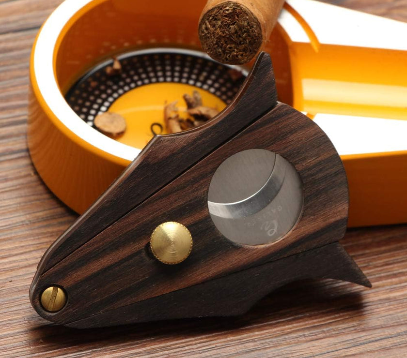 Cigar cutter with wooden handle and metal blade on a wooden surface