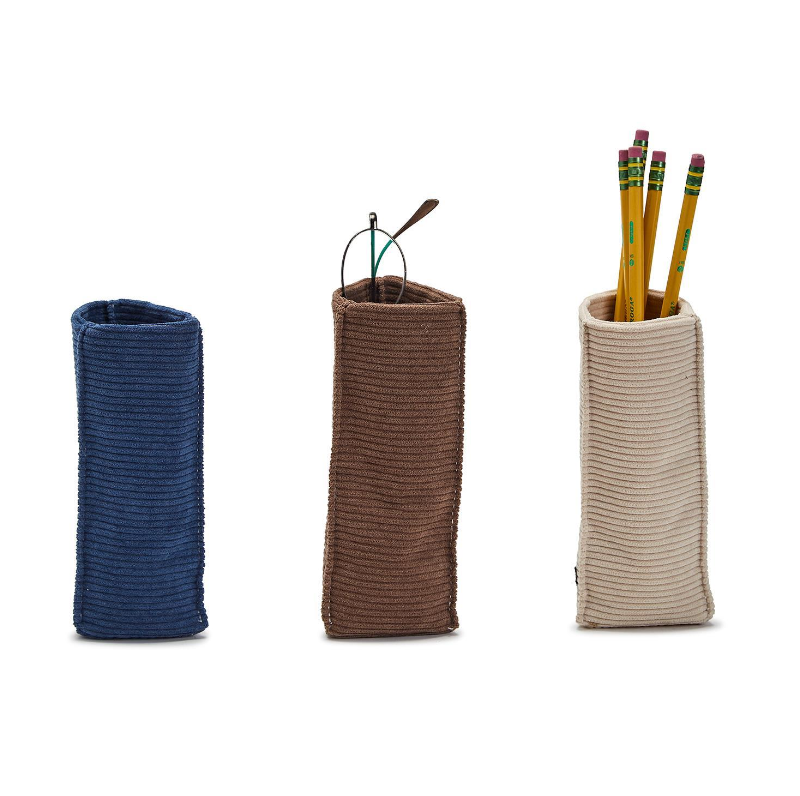 Three corduroy standing triangular weighted eyeglass/Accessory holders. One is filled with pens and pencils, the other two are empty.