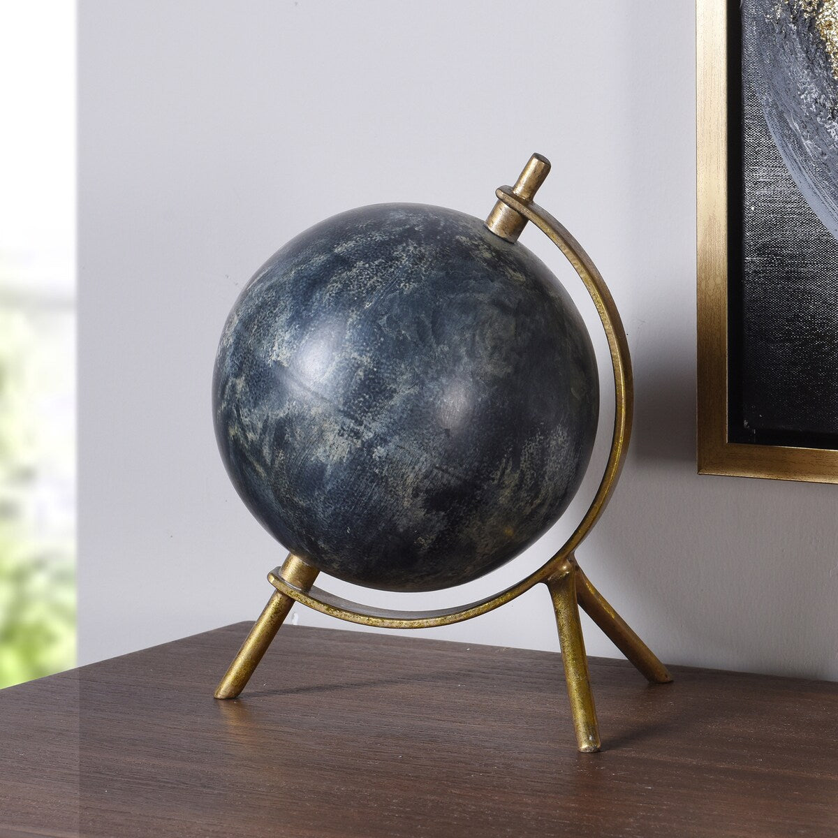 Decorative globe with gold stand on a wooden surface