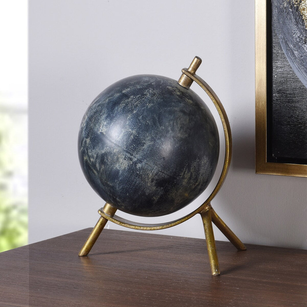 Decorative globe with gold stand on a wooden surface