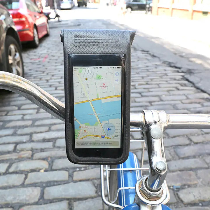 Phone mounted on a bicycle handlebar with a map displayed on the screen, on a street background.