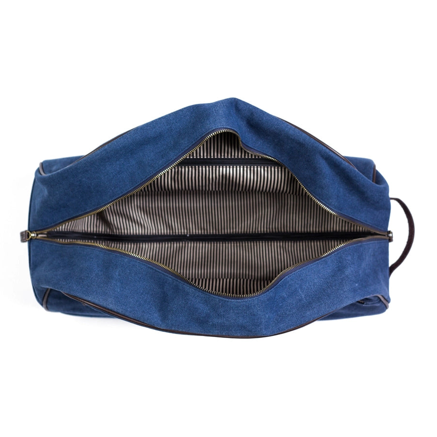 A blue trolley rolling duffel with the zippered top open to show a black and white striped interior.