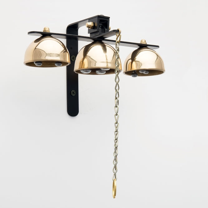 A gold-colored metal garden bell with a black mounting bracket and chain.