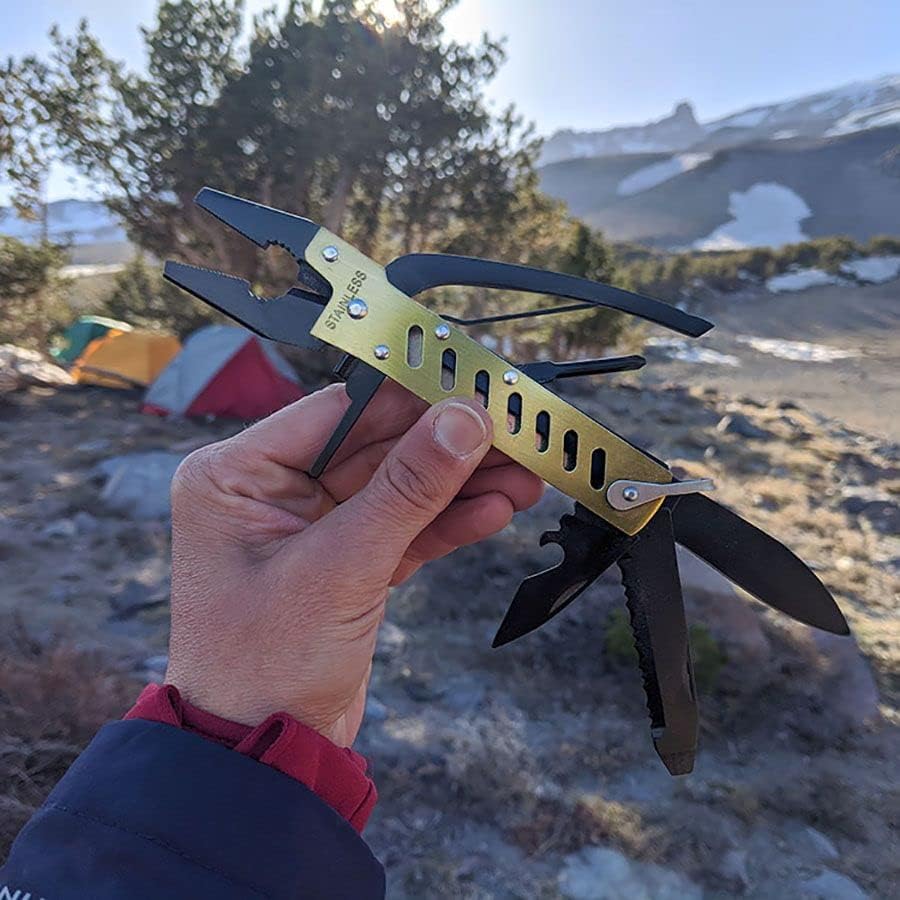 Multitool held in a hand with a mountainous landscape in the background