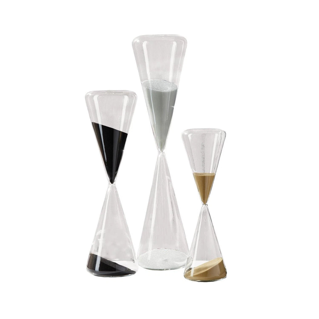 Set of three hourglass-shaped glass containers with different color sand on a white background
