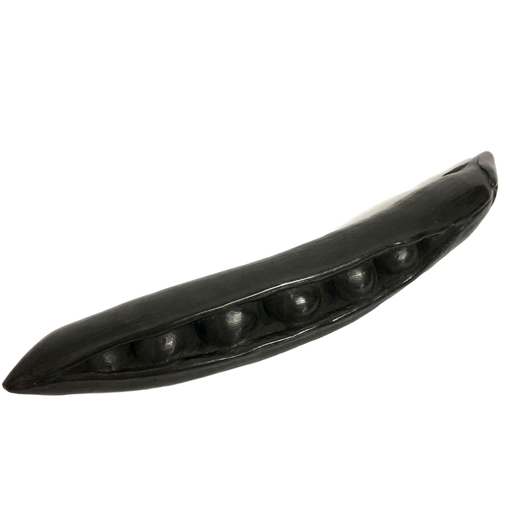 A hand-carved graphite object, crafted to look like a pea pod, displayed against a white background.