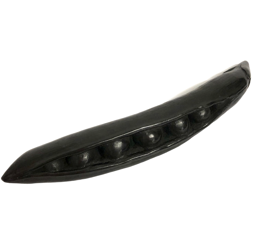A hand-carved graphite object, crafted to look like a pea pod, displayed against a white background.
