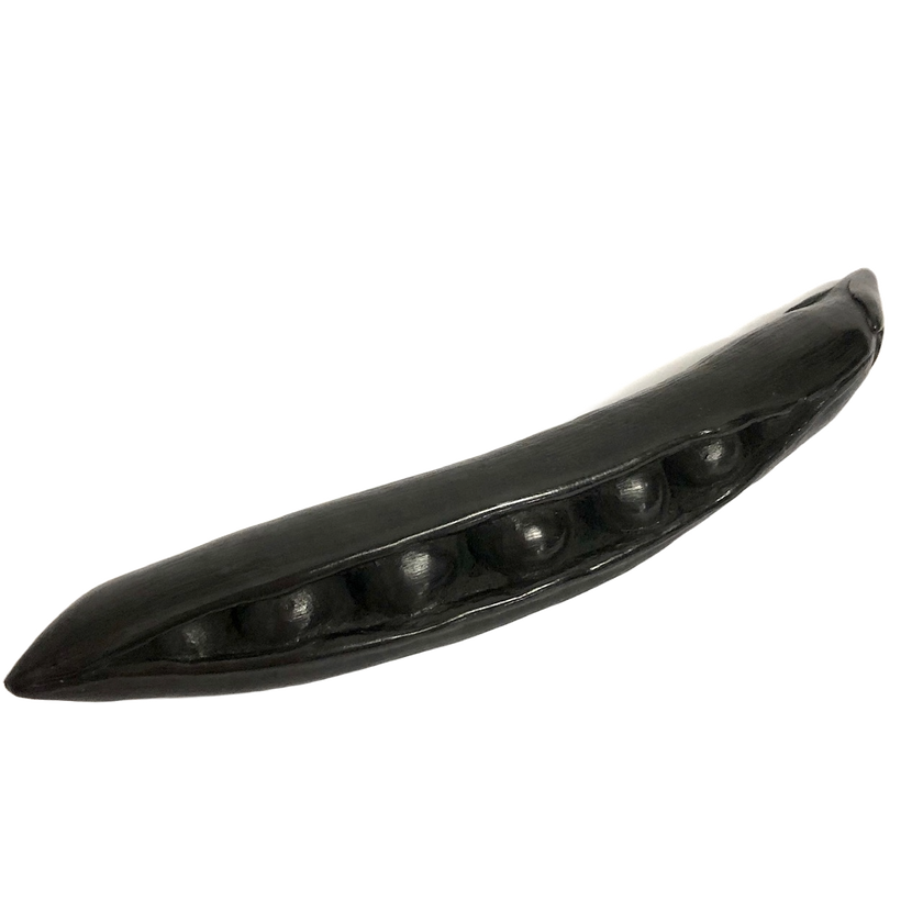 A hand-carved graphite object, crafted to look like a pea pod, displayed against a white background.