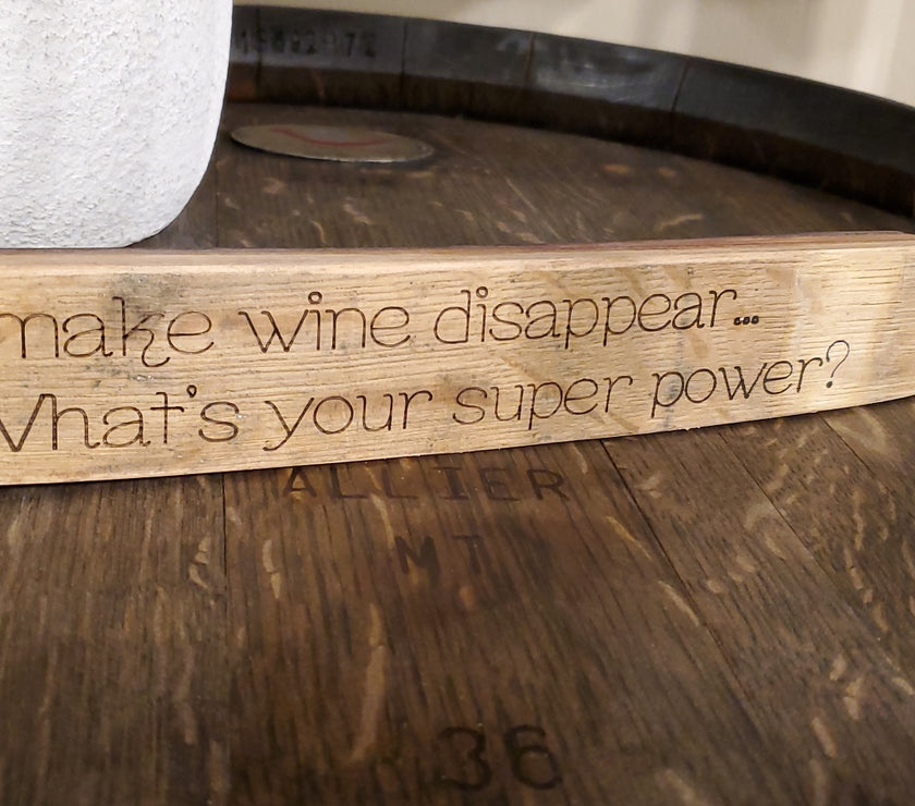 Wooden block with engraved text on a wooden surface
