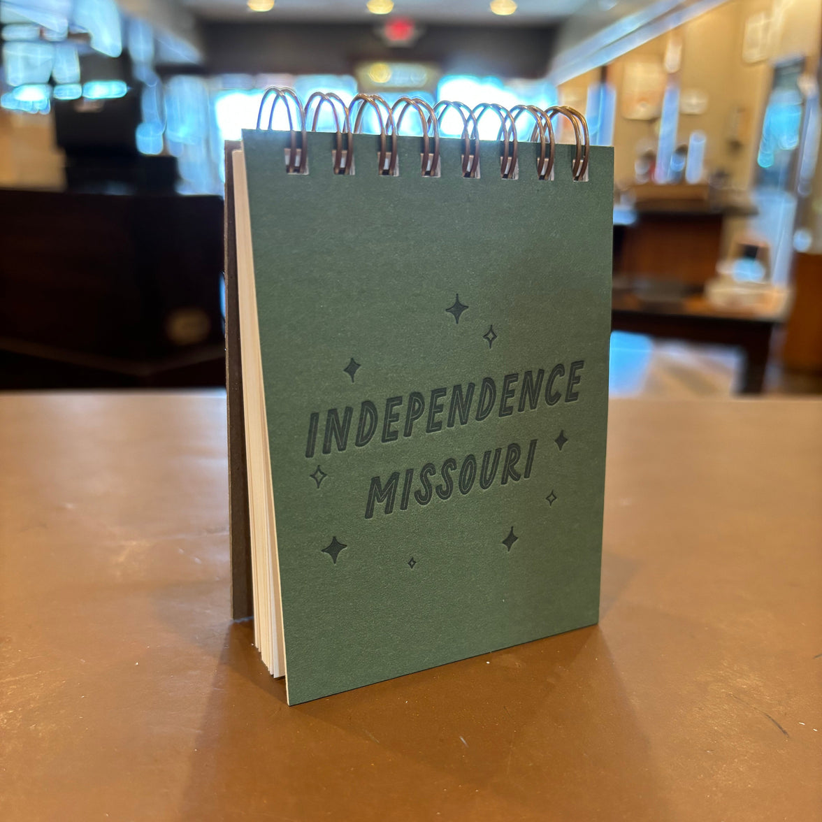A green spiral notebook with "Independence Missouri" stamped on the front.