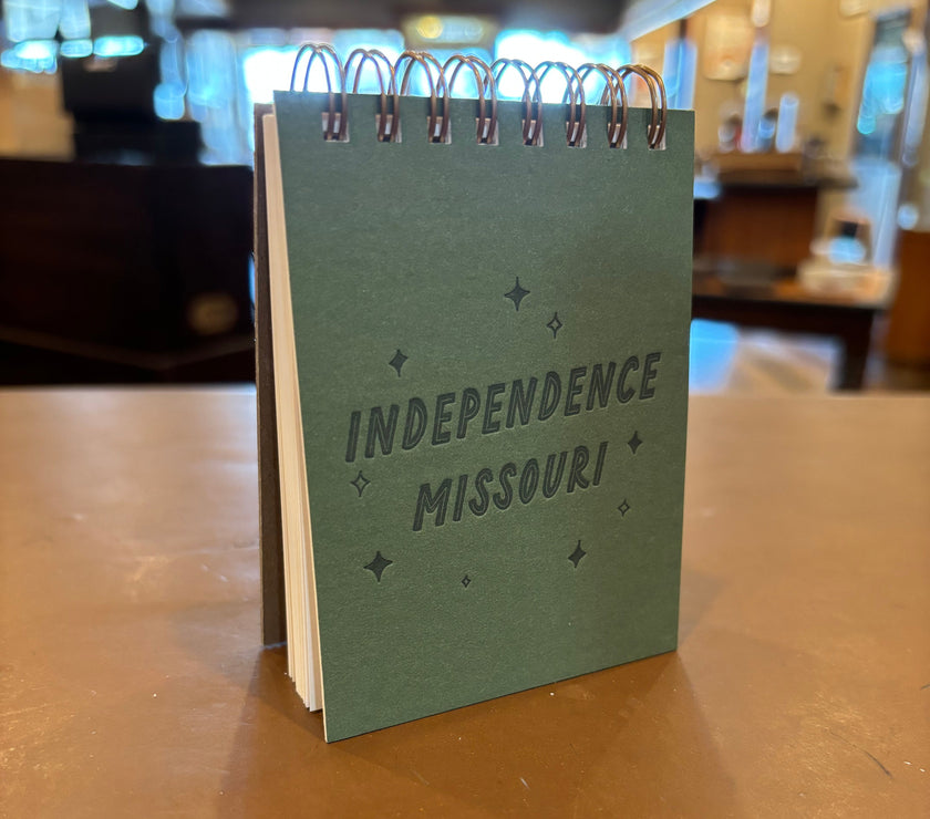 A green spiral notebook with "Independence Missouri" stamped on the front.