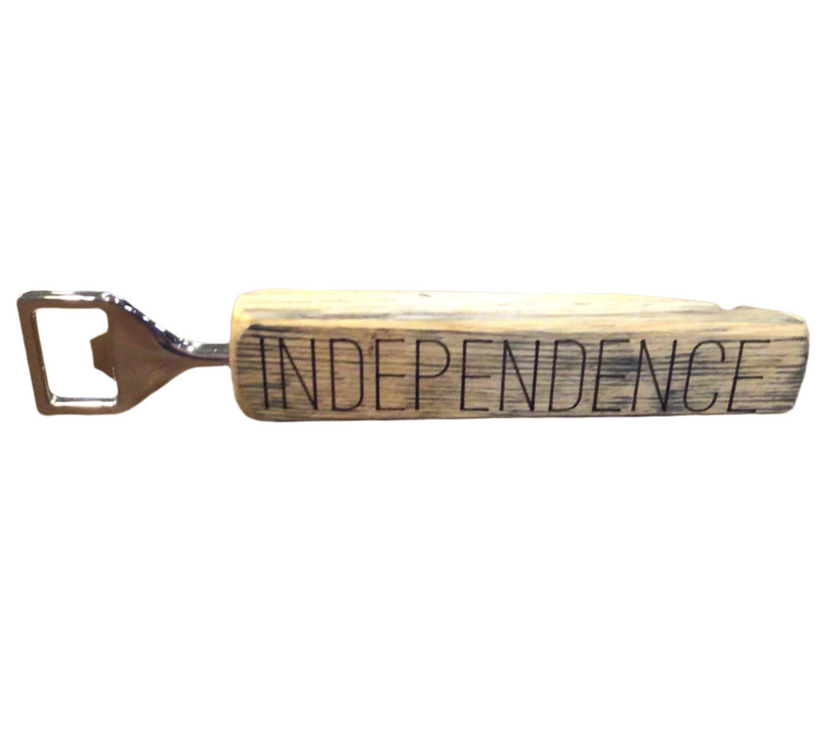 A wooden bottle opener with the engraved text 'INDEPENDENCE' on the handle.