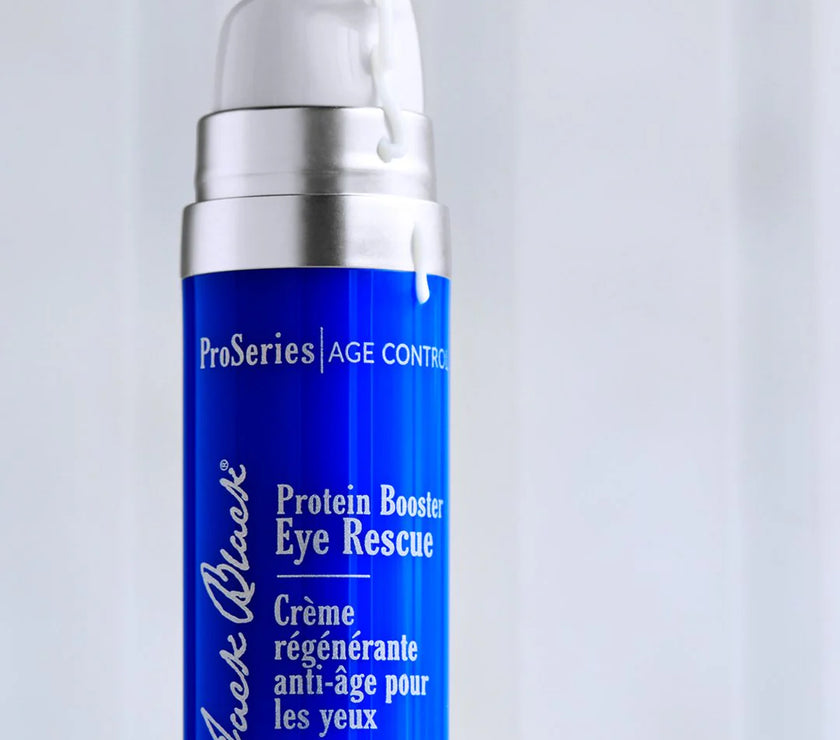 Blue skincare bottle labeled 'Protein Booster Eye Rescue' on a light gray background