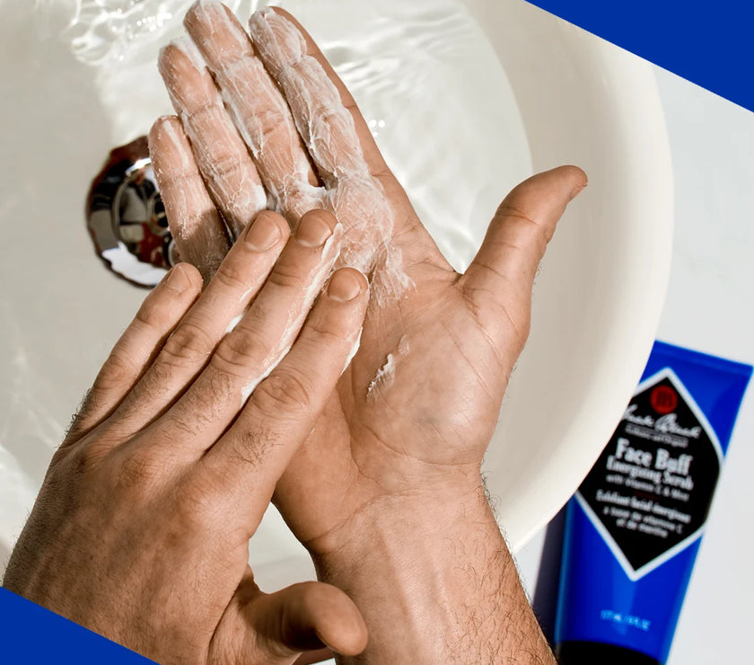 A person putting Jack Black Face Buff on their hands for use.