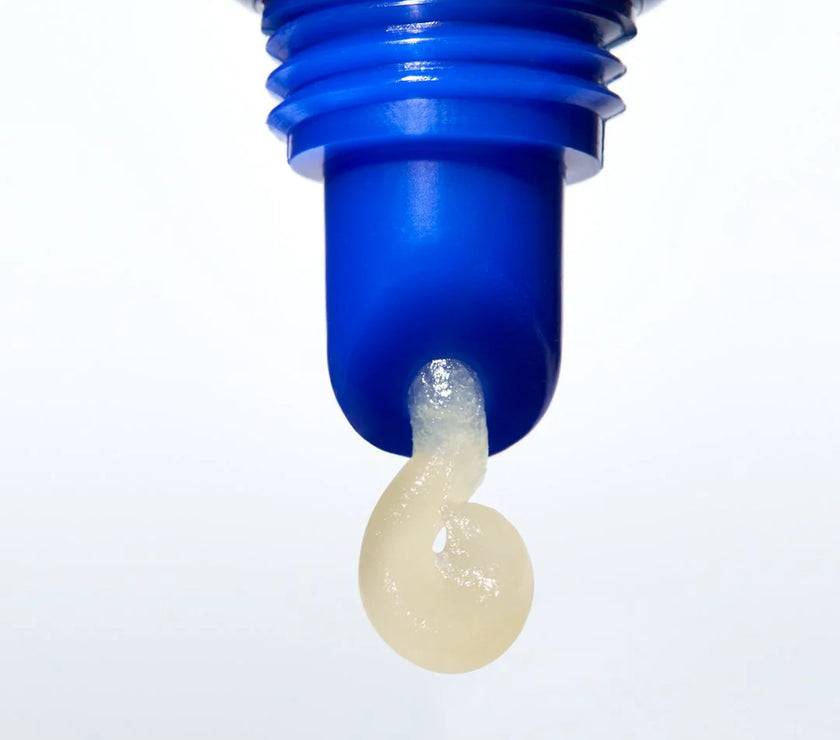 Blue bottle cap with a small amount of lip balm on a white background
