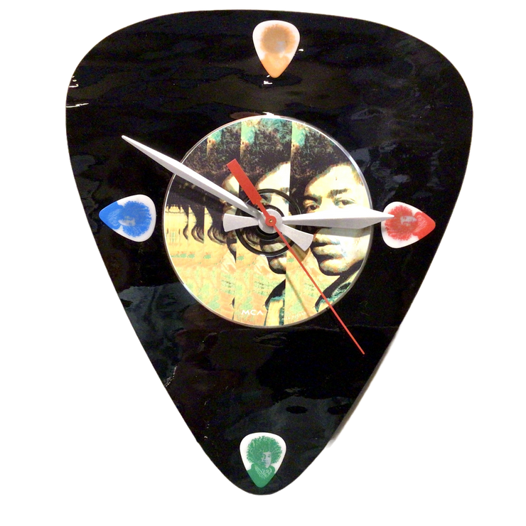 A decorative wall clock featuring a colorful image of a guitar and a portrait of Jimi Hendrix, with a black background and colorful accents.