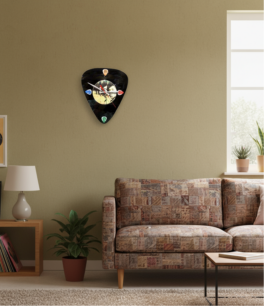 Living room with a guitar pick-shaped clock on the wall, a couch, and a shelf with books and a lamp.