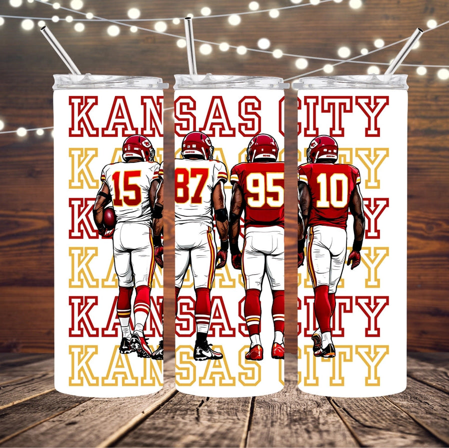 Tumbler with Kansas City Chiefs football players and text on a wooden surface with string lights.