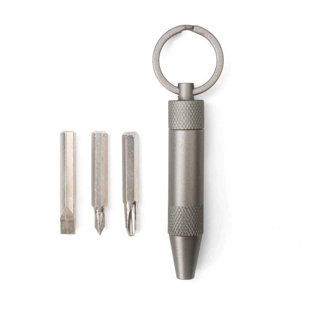 Metal keychain tool with three interchangeable bits on a white background