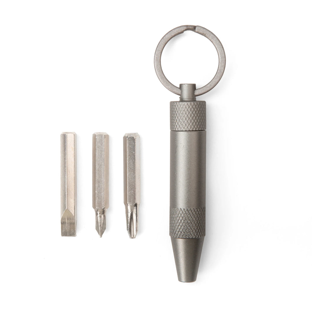Metal keychain tool with three interchangeable bits on a white background