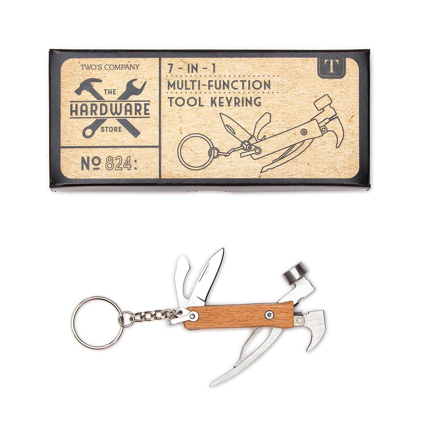 A beige 7-in-1 multi-function hammer tool keyring, displayed next to its packaging which indicates it's a product by Two's Company.