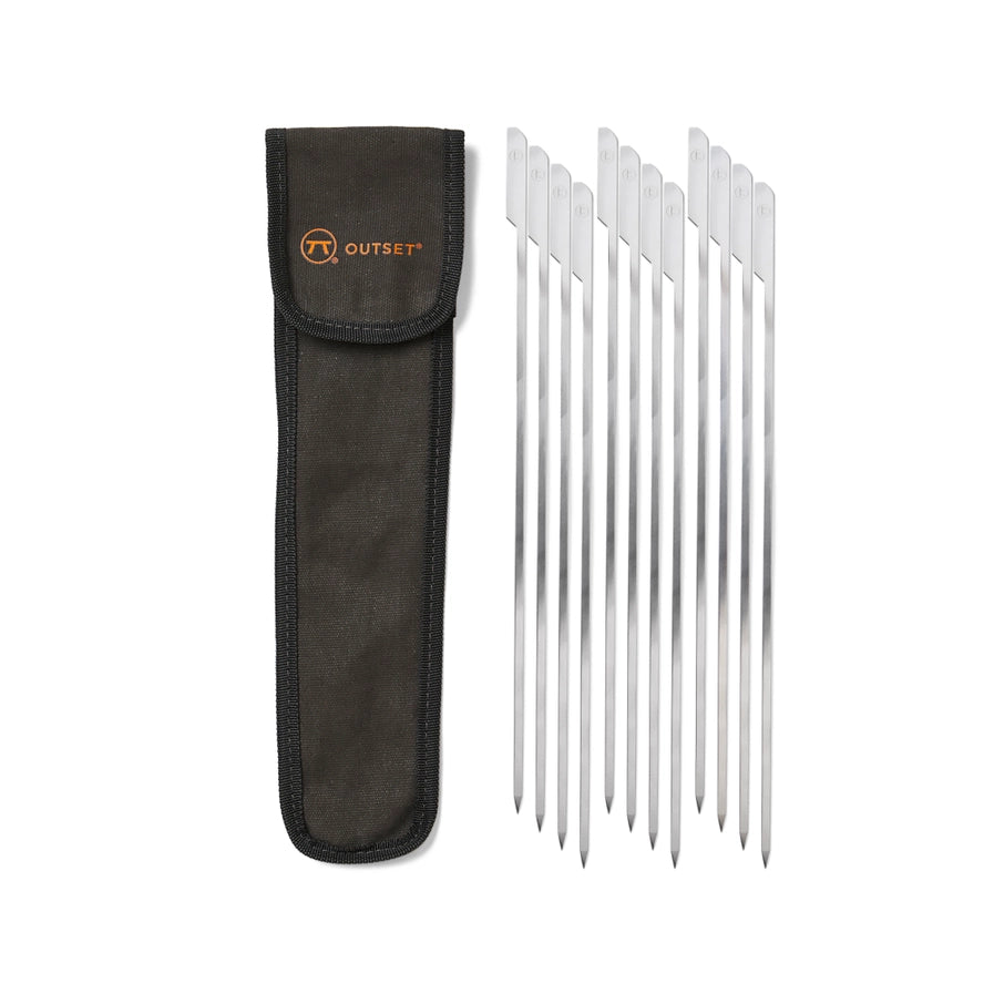 A set of 12 stainless steel grilling skewers with a flat paddled handle, displayed alongside a black canvas storage bag with the Outset logo.