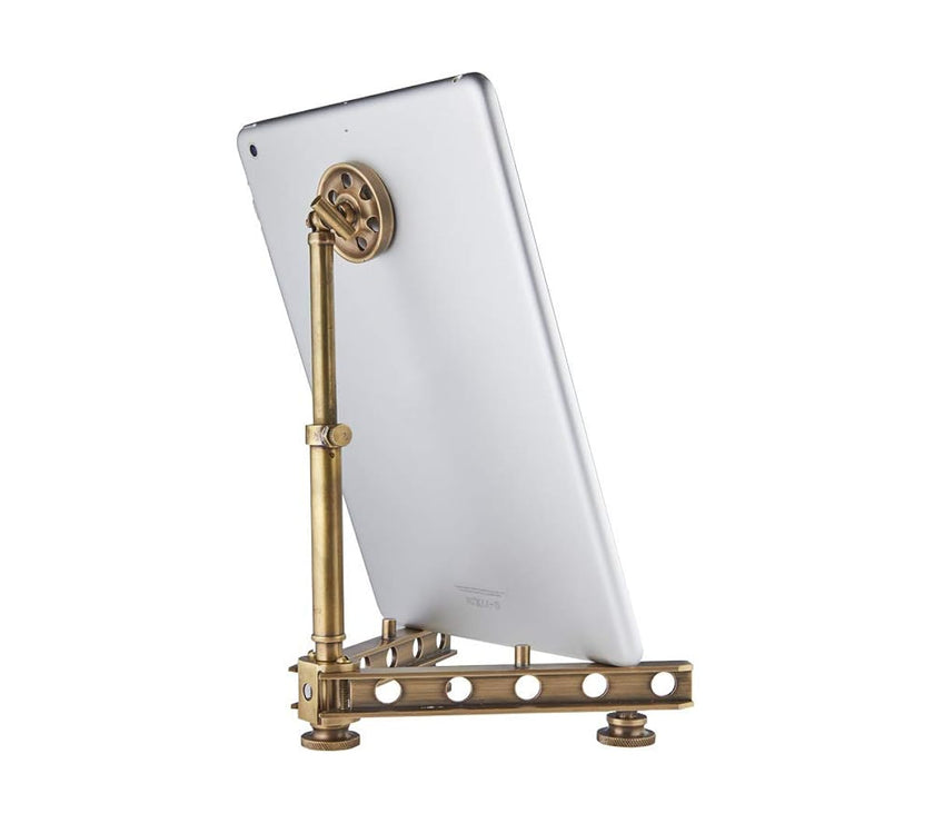 Brass tablet stand holding a white tablet on a white background