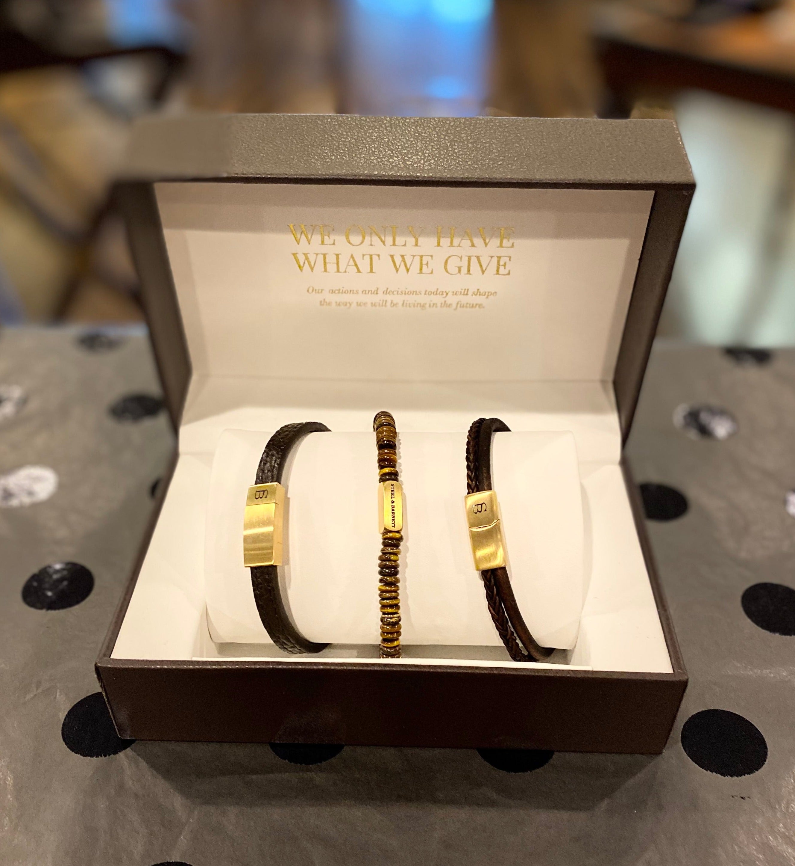 A set of three bracelets in a faux leather gift box, featuring beads and genuine leather with a stainless-steel clasp.