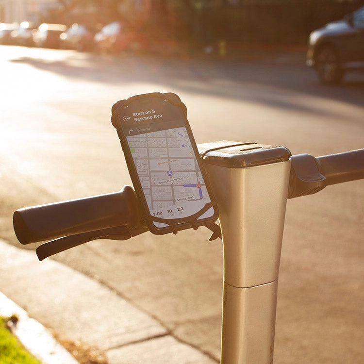 Smartphone mounted on a bicycle handlebar with a road and cars in the background