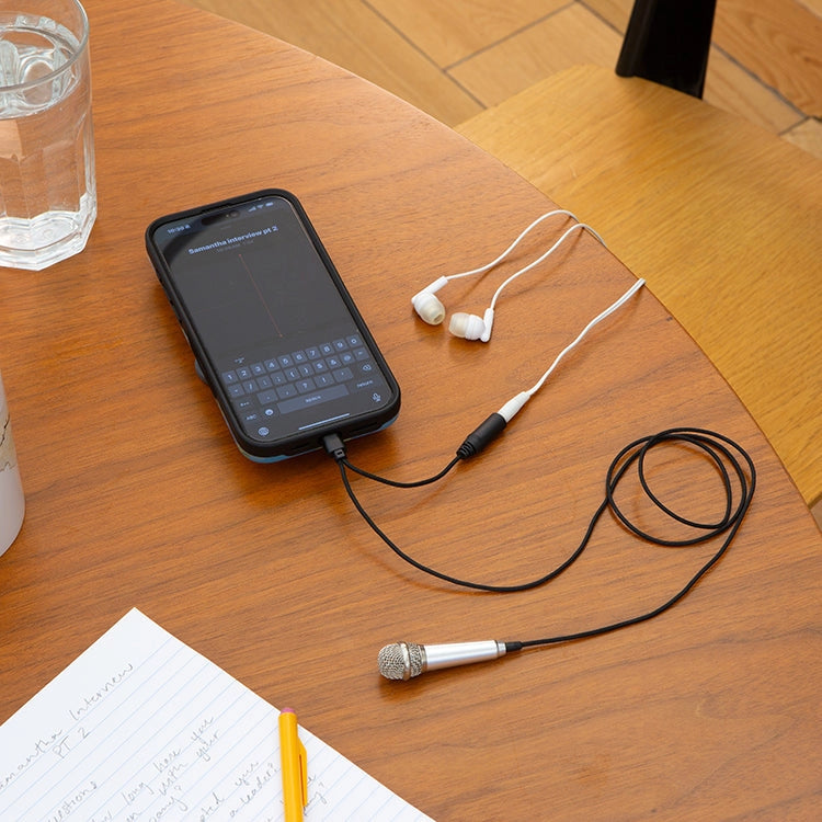 Phone with microphone and headphones on a wooden table