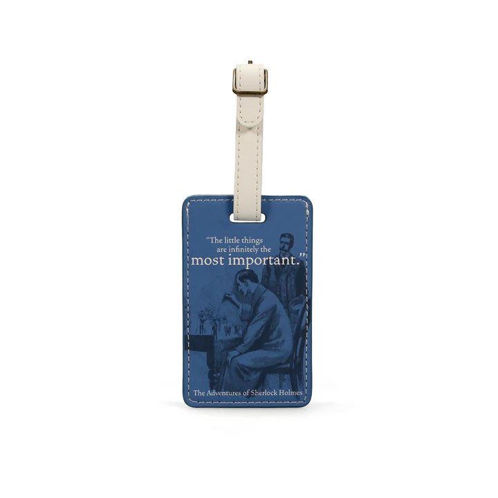 A blue luggage tag featuring an image of Sherlock Holmes and the quote "the little things are infinitely the most important" and a white buckle attachment.