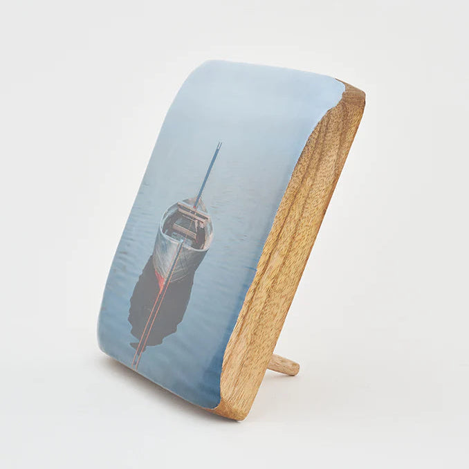 A decorative wooden block featuring a printed image of a rowboat on water.