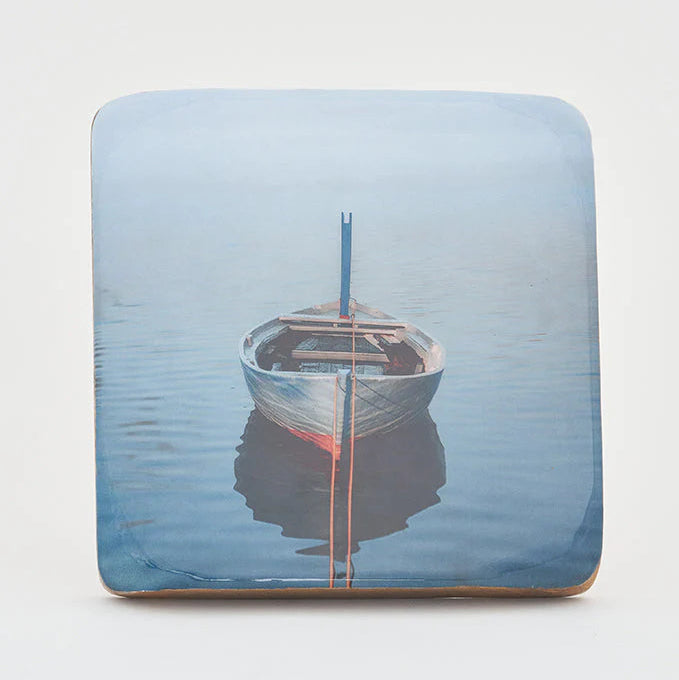 A decorative wooden block featuring a printed image of a rowboat on water.