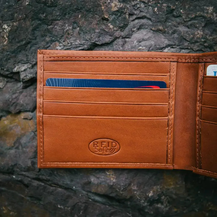 Brown leather wallet with card slots on a stone background